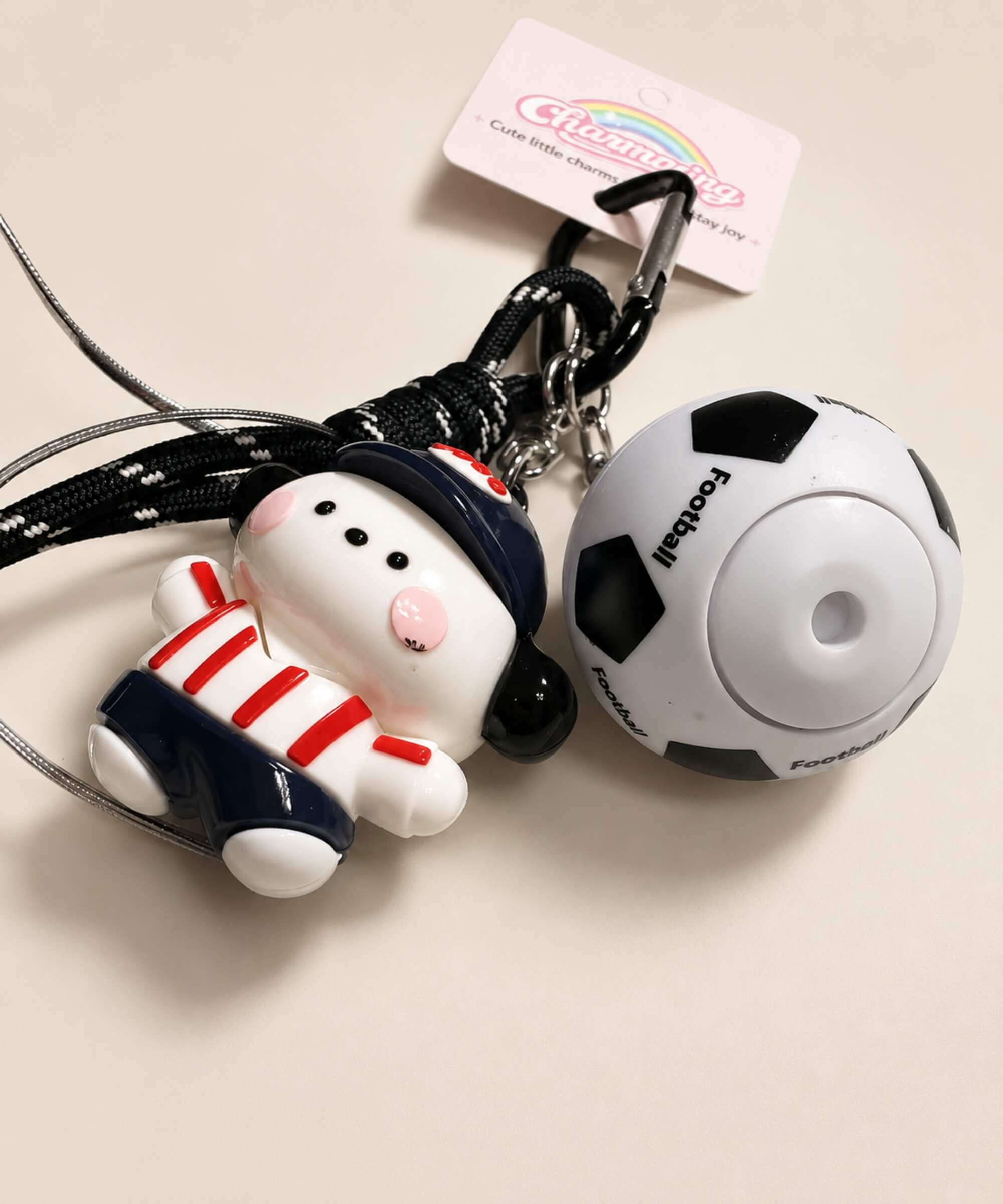 Close-up of red stripe dog soccer ball spinner keychain with football charm and rope-style strap